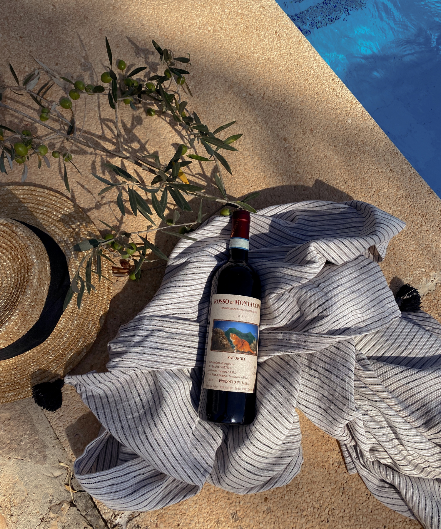 Bottle Rosso di Montalcino on the ground next to pool