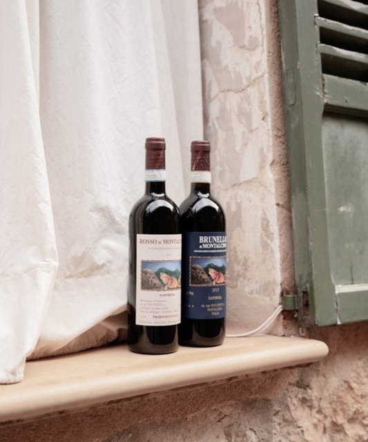 2 bottles of red wine brunello and rosso in window